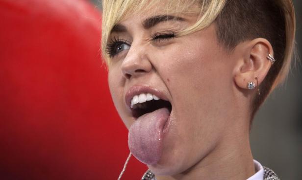 Miley Cyrus streckt die Zunge heraus und zwinkert.