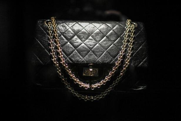 Eine schwarze gesteppte Handtasche mit goldenen und silbernen Kettenriemen.