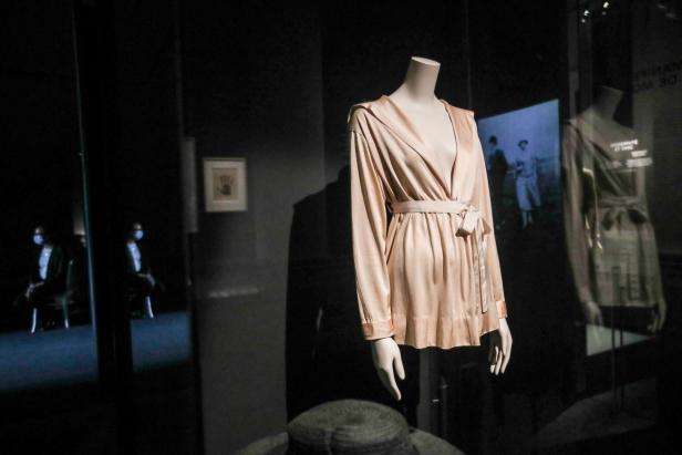 Eine hellrosa Robe auf einer Schaufensterpuppe in einer Museumsausstellung.