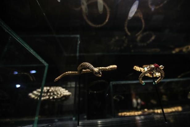Verschiedene goldene Schmuckstücke, darunter eine Schlange, in einer Vitrine.