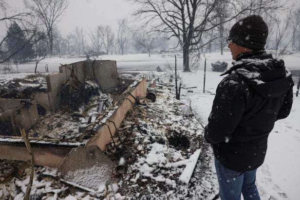 Chris Dreier looks at his house burned by wildfires, in Colorado