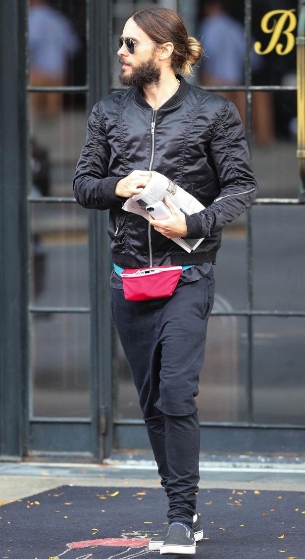 Jared Leto mit Sonnenbrille, Bomberjacke und Zeitung in der Hand.