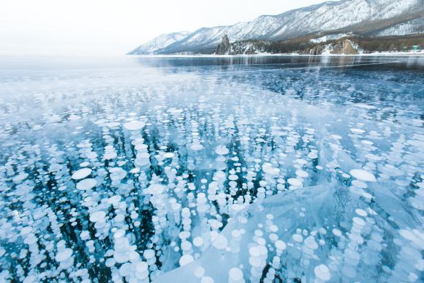 Gefrorener Baikalsee mit Methanblasen unter der Eisoberfläche.