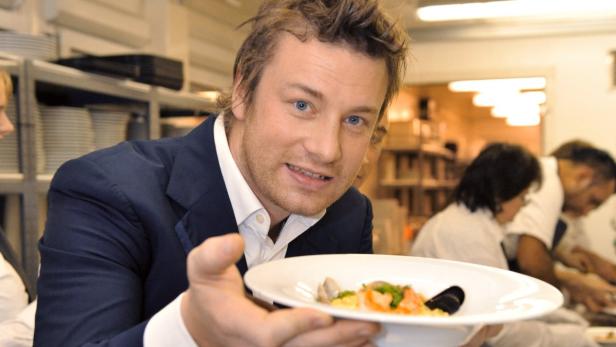Jamie Oliver präsentiert ein Tellergericht mit Meeresfrüchten.