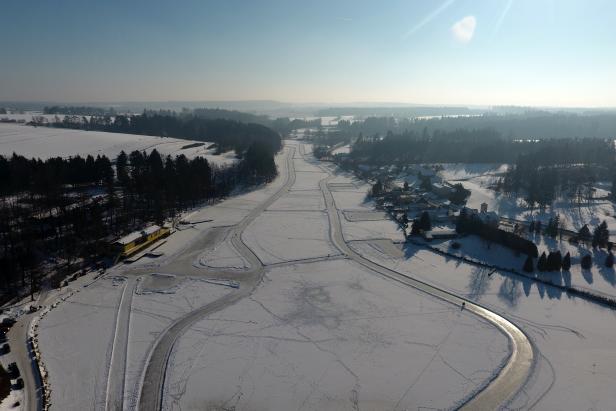 Luftaufnahme einer verschneiten Landschaft mit einer Eisbahn.
