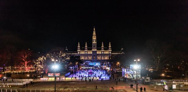 Der Wiener Eistraum vor dem beleuchteten Rathaus bei Nacht.