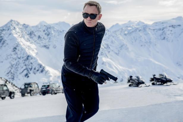 Daniel Craig als James Bond in einer verschneiten Berglandschaft mit einer Pistole in der Hand.
