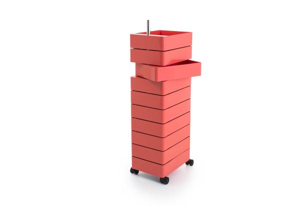 Ein korallfarbener Turm aus quadratischen Schubladen auf Rollen steht auf einem weißen Hintergrund.