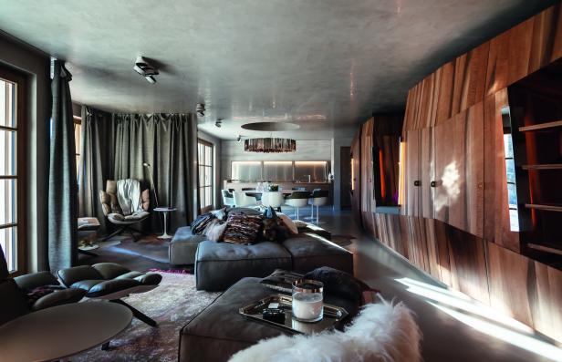 Ein modernes Wohnzimmer mit grauen Möbeln und einer Holzwand.