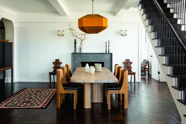 Ein Esszimmer mit einem Holztisch, Stühlen und einer auffälligen, orangefarbenen Lampe.