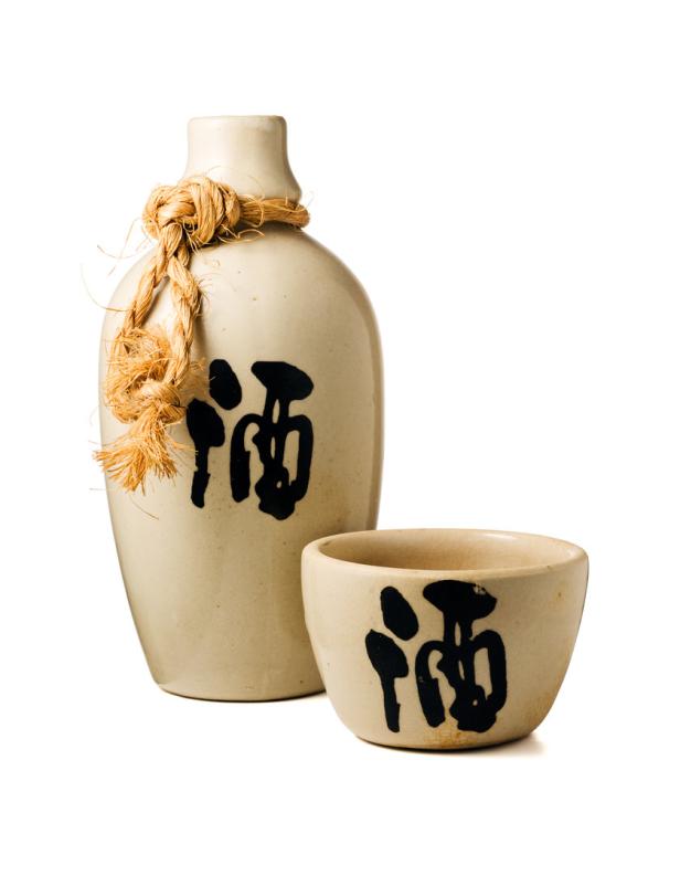 Eine Sake-Flasche und eine Schale mit japanischen Schriftzeichen.