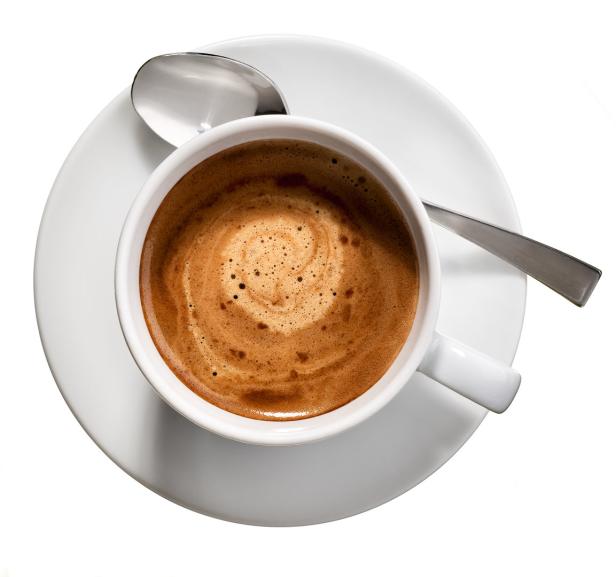 Eine Tasse Kaffee mit Milchschaum auf einer Untertasse mit einem Löffel.