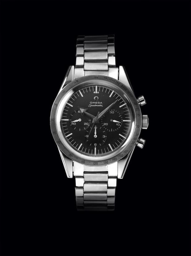 Eine silberne Omega Speedmaster Uhr vor einem schwarzen Hintergrund.