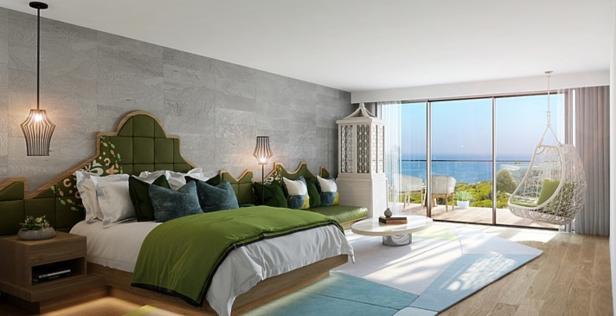 Ein Schlafzimmer mit Meerblick, eingerichtet mit einem grünen Bett und einem Hängesessel.