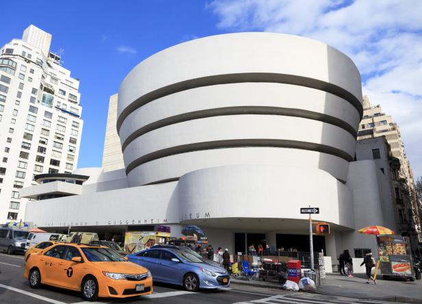 Das Solomon R. Guggenheim Museum in New York mit einem gelben Taxi im Vordergrund.