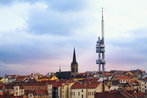 Blick auf Prag mit dem Žižkov-Fernsehturm und einer Kirche.