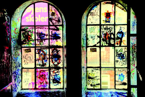 Zwei alte Fenster sind mit Graffiti bedeckt.