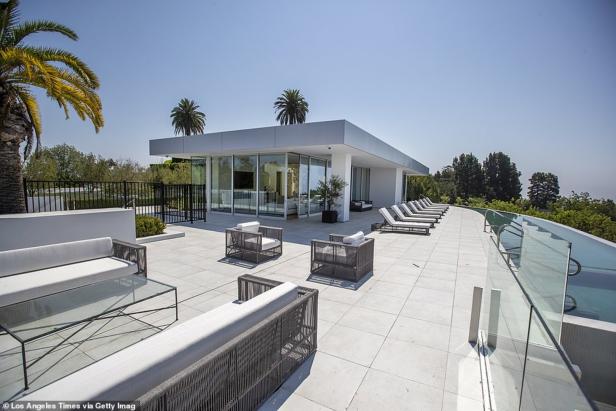 Eine Terrasse mit modernen Möbeln und einem Infinity-Pool an einem sonnigen Tag.