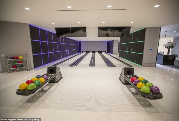 Eine moderne Bowlingbahn mit farbigen Bowlingkugeln und beleuchteten Wänden.