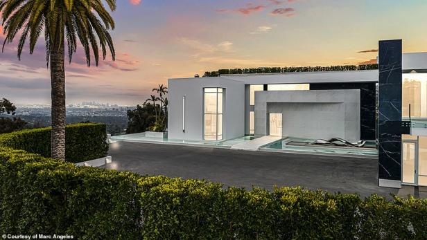 Ein modernes Haus mit Pool und Blick auf die Skyline der Stadt bei Sonnenuntergang.