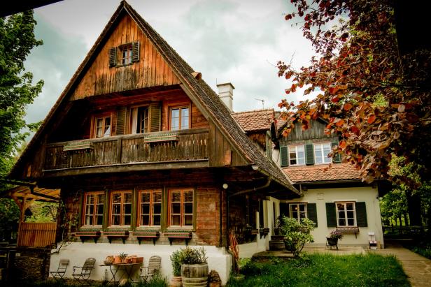 Ein großes Holzhaus mit einem Giebeldach und vielen Fenstern.