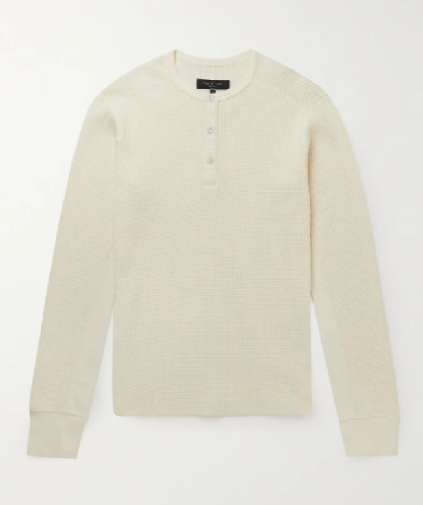 Ein cremefarbenes Henley-Shirt mit langen Ärmeln liegt auf einem weißen Hintergrund.