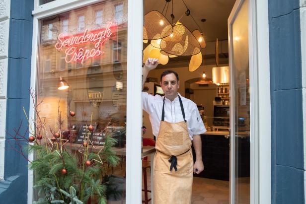 Ein Koch steht in der Tür eines Restaurants, das „Sourdough Crêpes“ anbietet.