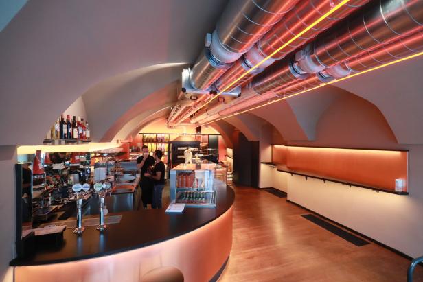 Innenansicht einer Bar mit zwei Angestellten hinter der Theke.