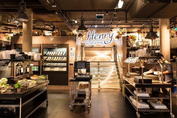Innenansicht eines „Henry the art of living“-Geschäfts mit Speisen und Treppe.