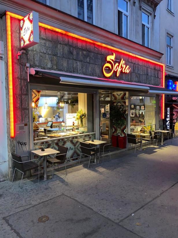 Das Restaurant „Sofra“ mit Tischen im Freien am Abend.