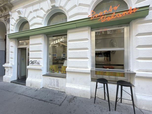 Die Fassade eines Pizza-Restaurants mit dem Neon-Schriftzug „Pronto Volante“.