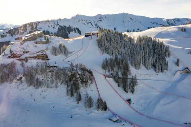 Luftaufnahme einer Skipiste in einem verschneiten Berggebiet.