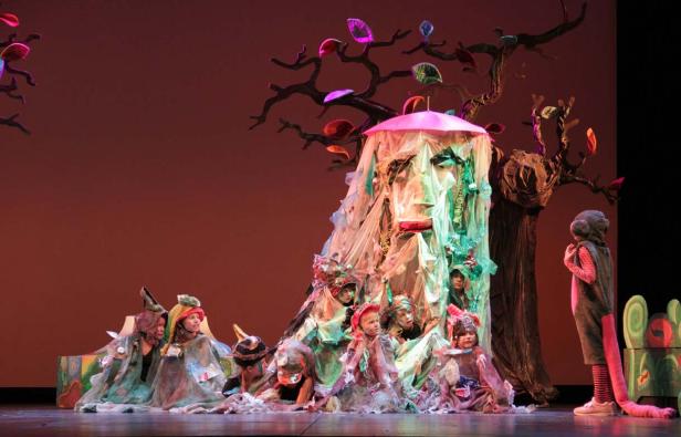Eine Gruppe von Kindern in Kostümen auf einer Bühne während einer Theateraufführung.