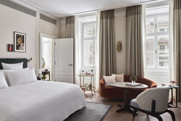 Ein Hotelzimmer mit einem Bett, einem Sofa, einem Tisch und einem Servierwagen.