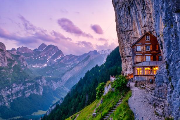 Das Gasthaus Aescher-Wildkirchli schmiegt sich an eine Felswand in den Schweizer Alpen.