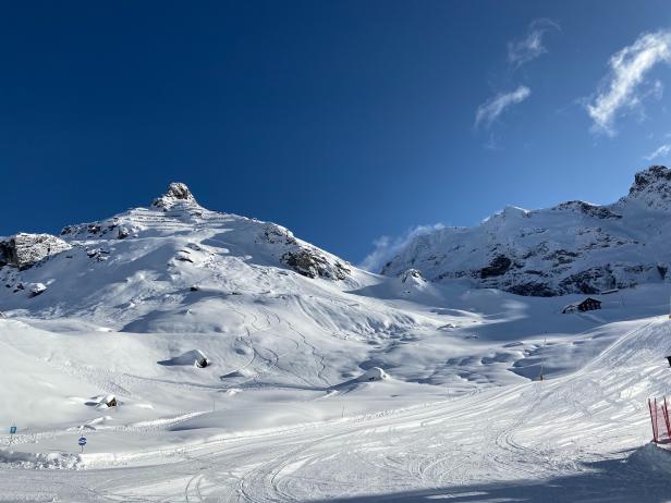 Verschneite Berge unter einem strahlend blauen Himmel.