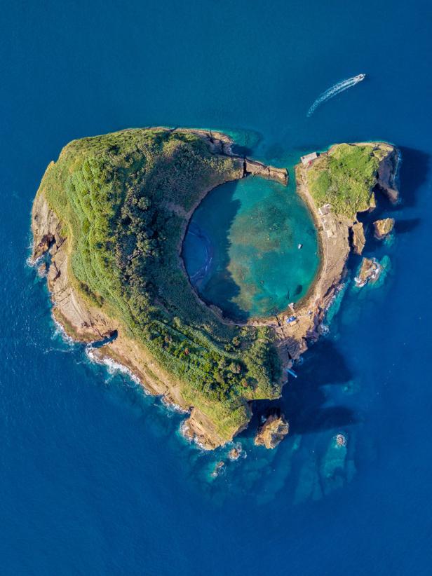 Luftaufnahme von Vila Franca do Campo, einer kleinen Insel der Azoren mit einem kreisrunden See in der Mitte.