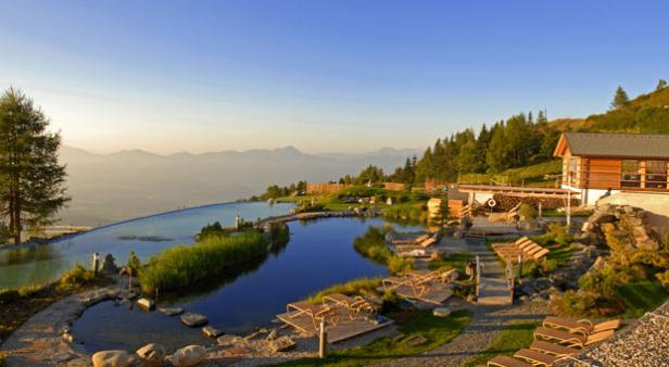 Ein Bergresort mit Pools, Liegestühlen und Blick auf die Alpen.