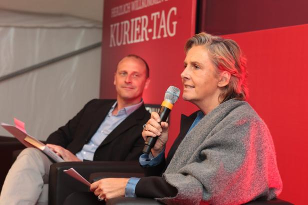 Eine Frau spricht bei einer Veranstaltung des „Kurier-Tag“ in ein Mikrofon.