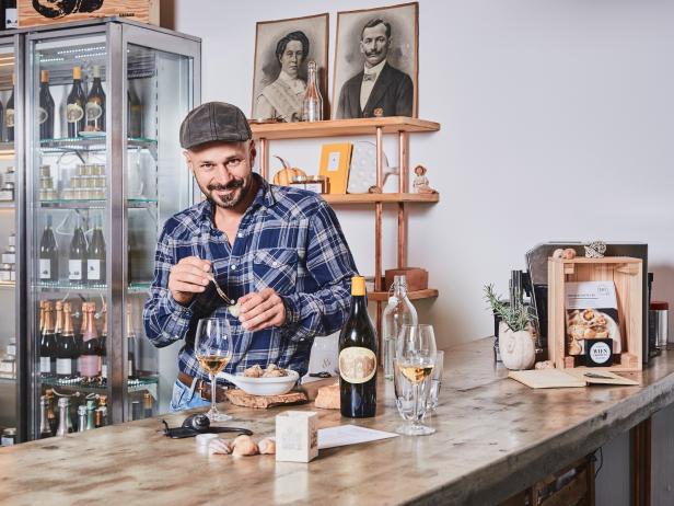 Ein Mann in einer Weinbar bereitet Schnecken mit Wein vor.