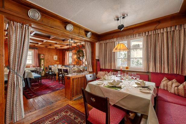 Ein traditionell eingerichtetes Restaurant mit gedeckten Tischen und roter Einrichtung.