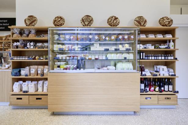 Ein Verkaufsregal mit Lebensmitteln wie Brot, Milchprodukten und Konserven in einem Geschäft.