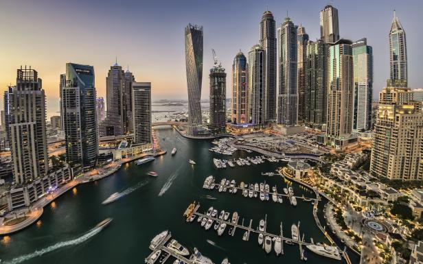 Blick auf die Skyline von Dubai Marina mit zahlreichen Wolkenkratzern und Yachten im Hafenbecken.