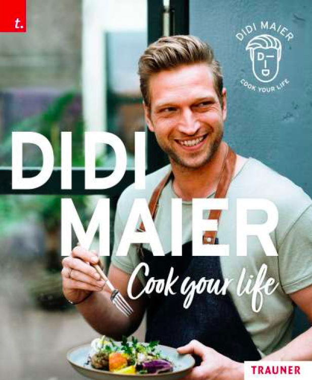 Didi Maier, ein Koch, hält einen Teller mit Salat in der Hand.
