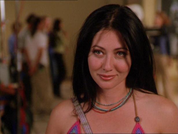 Shannen Doherty lächelt mit dunklen Haaren und einer Halskette.