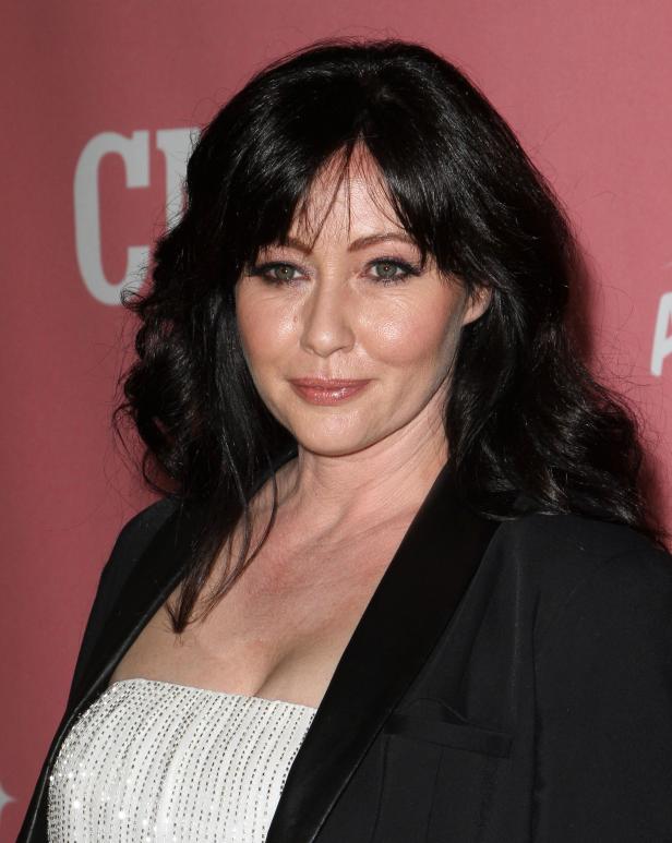 Ein Porträt von Shannen Doherty auf einem roten Teppich.