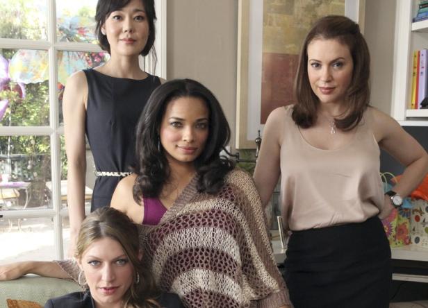 Vier Frauen posieren für ein Gruppenfoto in einem Wohnzimmer.
