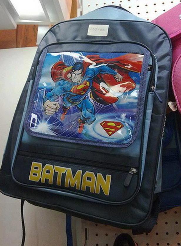 Ein grauer Rucksack mit einem Superman-Motiv und dem Schriftzug „Batman“.