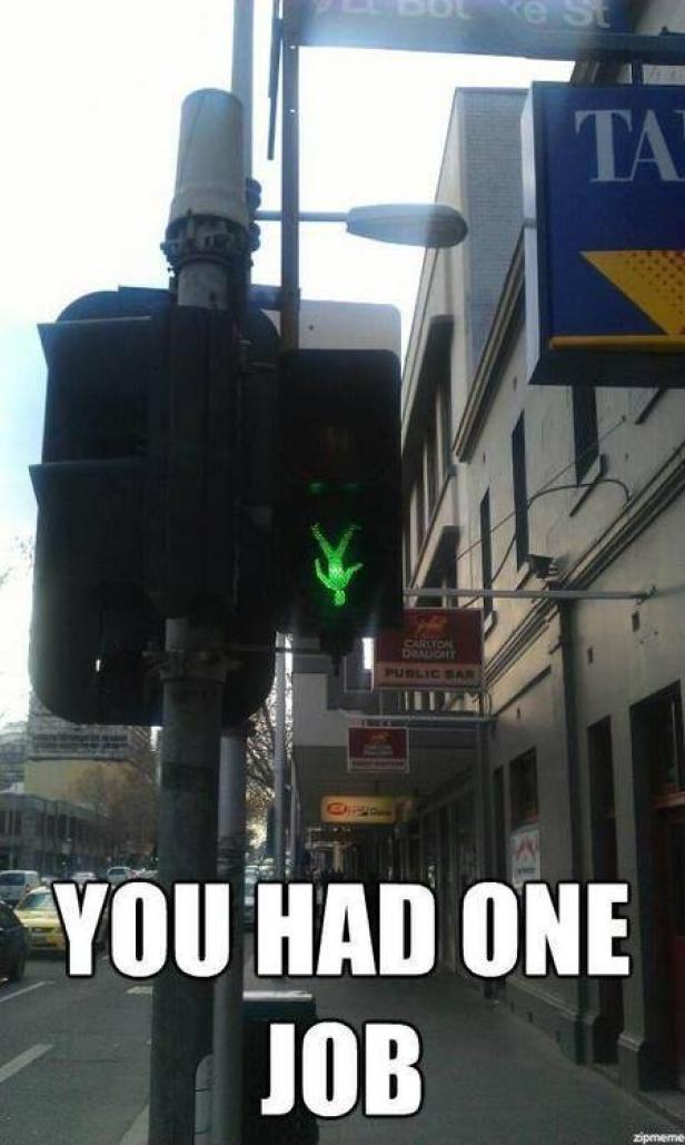 Eine Fußgängerampel zeigt ein grünes, auf dem Kopf stehendes Männchen.