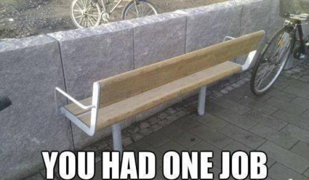 Eine Parkbank wurde direkt vor einer Mauer auf einem Bürgersteig montiert.